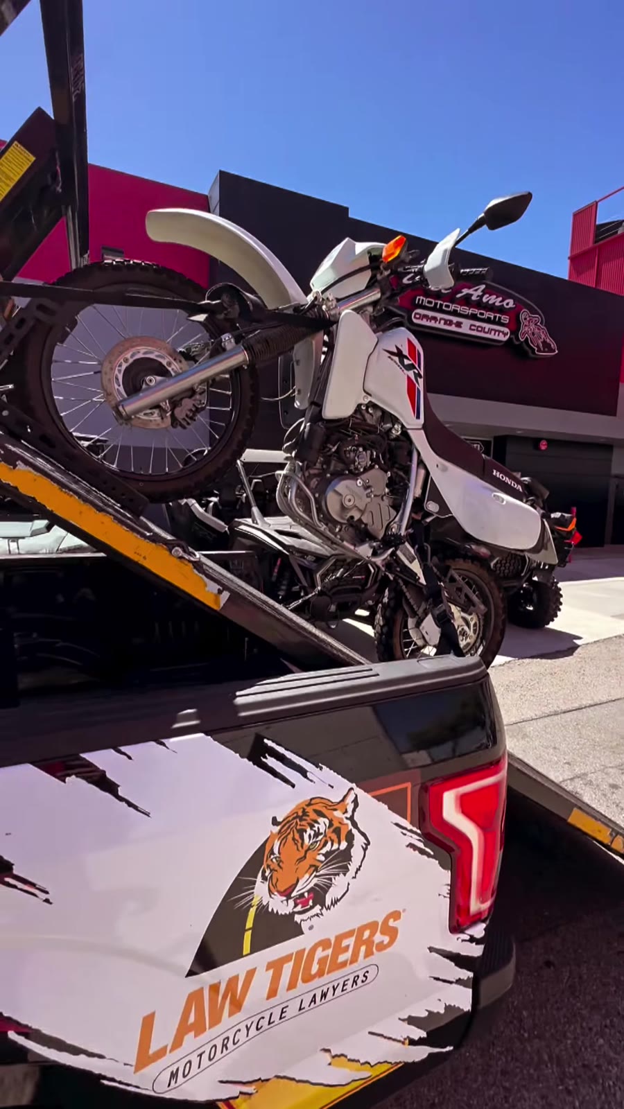 Honda XR dual-sport on Law Tigers black truck at Del Amo