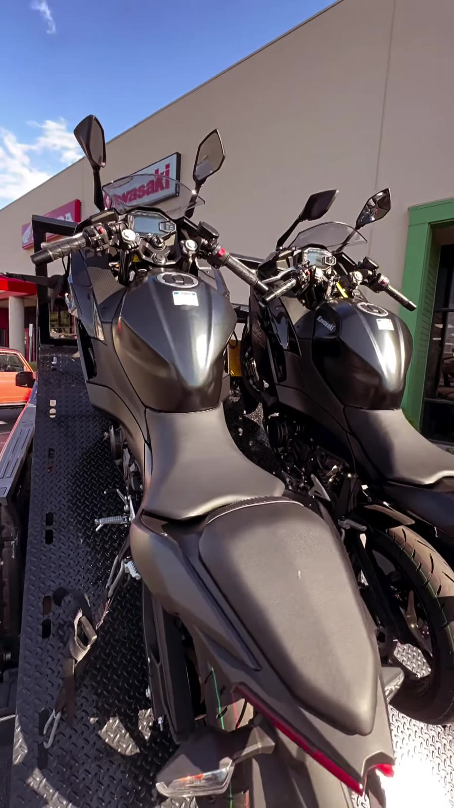 Two black Kawasaki Ninjas on black flatbed